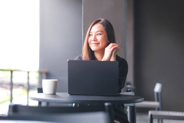 istock Portrait image of a young woman working on laptop computer in cafe 2155683109