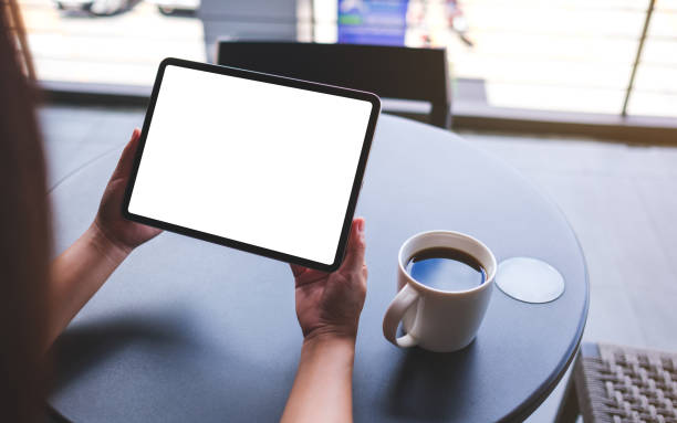 istock Mockup image of a woman holding digital tablet with blank white desktop screen in cafe 2155683127