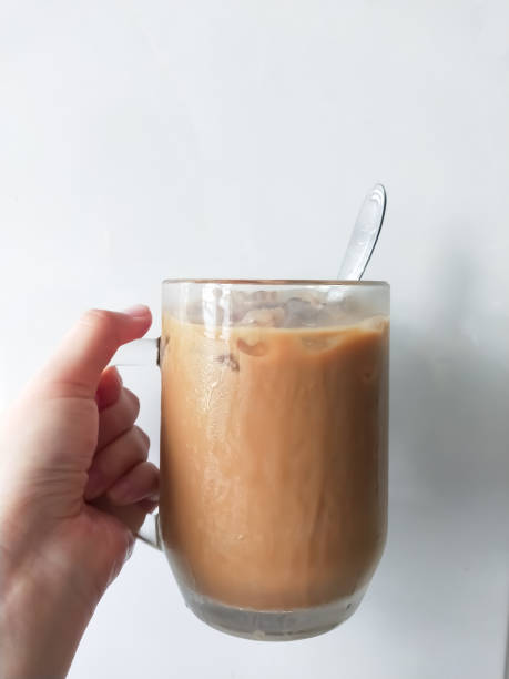 istock a person is holding a cup of coffee with a spoon in it. 2155683195