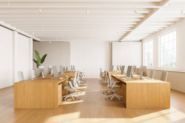 istock Wooden coworking interior with pc computers on desks in row, panoramic window 2155685120