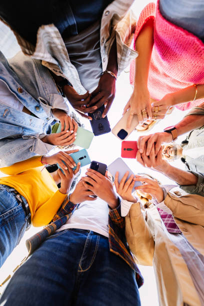 Young group of student people using mobile phone together outside stock photo