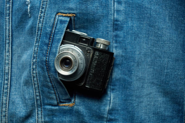 Vintage film camera in denim jacket pocket