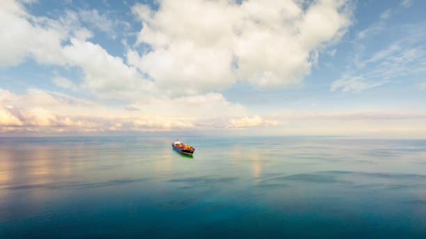 istock Aerial front view of a large container cargo ship travels over calm, blue ocean. 2155695708