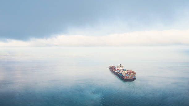 istock Aerial front view of a large container cargo ship travels over calm, blue ocean. 2155696713