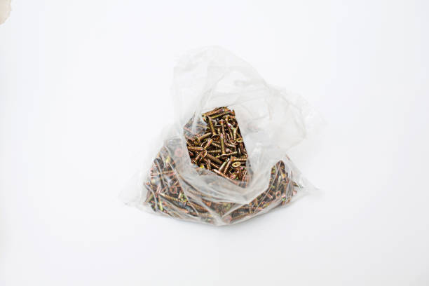 The metal drilled screw nut is in a plastic bag. Isolated from white background
