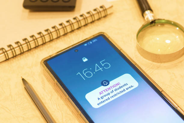 istock Smartphone notification on display about students going into restricted areas. Geofencing or geo-tracking alert concept. 2155697717