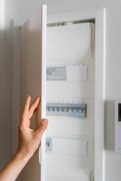 istock Woman open metal door on control panel at home electric shield 2155700156