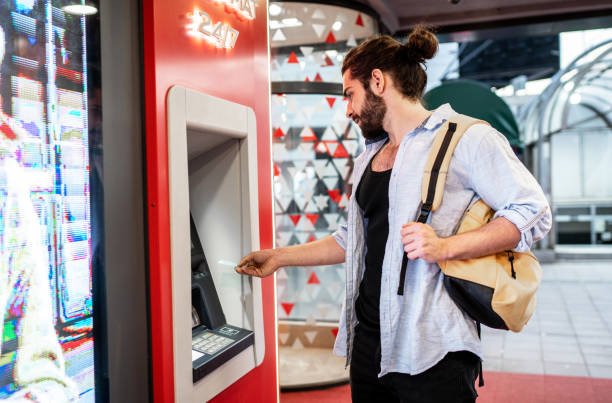 istock Young man withdrawing money from a cash machine 2155702904