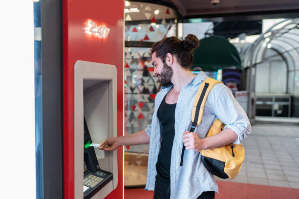 istock Young man withdrawing money from a cash machine 2155702939