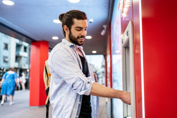 istock Young man withdrawing money from a cash machine 2155702984