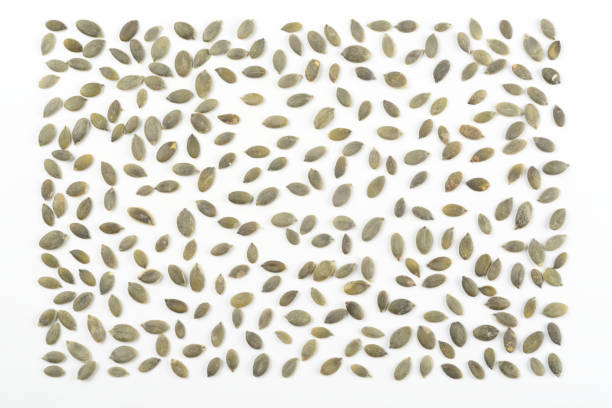 Peeled pumpkin seeds on white background, composition as a background