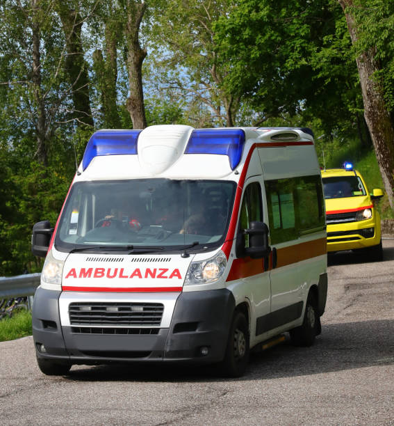 istock White emergency van with text AMBULANZA that means AMBULANCE in italian language and  flashing blue flashings and siren during an emergency call 2155709562