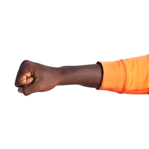 istock Fisted hand in orange sweater giving a punch, fist over white background 2155709621