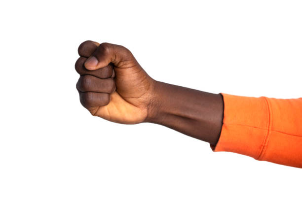 Fisted hand in orange sweater giving a punch, fist over white background
