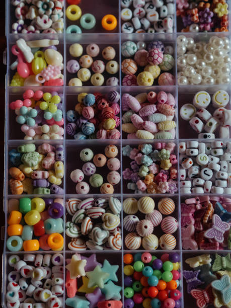 istock Kids Bead Set: A vertical, straight-from-above close-up shot captures beads in a plastic box, divided into sections based on their shapes, colors, and forms. 2155710172