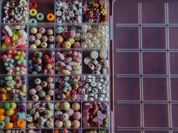 istock Kids Bead Set: A horizontal, straight-from-above close-up shot captures beads in a plastic box, divided into sections based on their shapes, colors, and forms. 2155710194