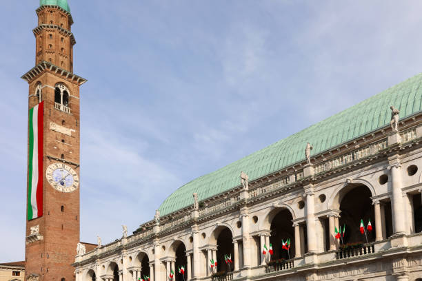 Vicenza, VI, Italy - May 10, 2024: Civic Tower Called Torre Bissara and landmark called Basilica Palladiana with flags