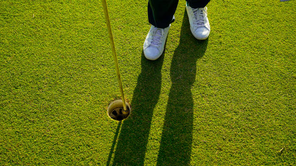 istock golfer holding the flag hole on a putting green on the golf course. 2155719157