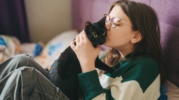istock Kid in bed is kissing her cat 2155720088
