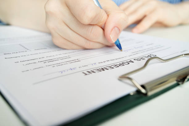 istock Sales agreement, hand fills out a document, client signature,  purchase order, customer satisfaction 2155725158