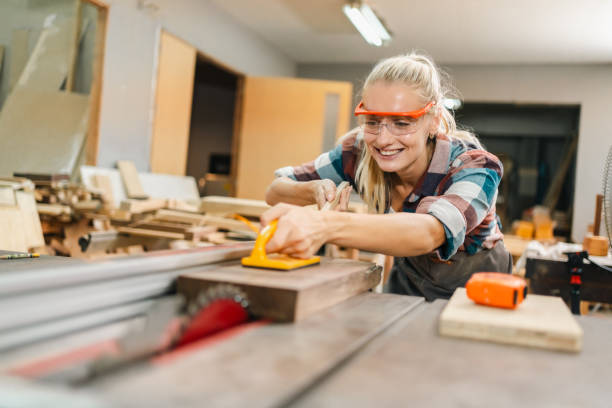 istock Attractive middle aged woman carpenter designer works with ruler, make notches on the tree in workshop. Image of modern femininity. Concept of professionally motivated women 2155727124