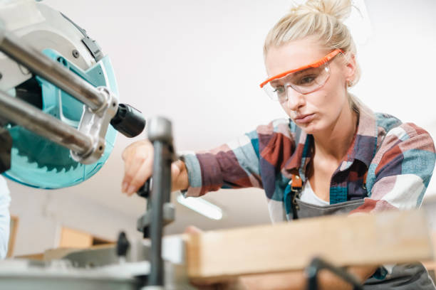 istock Attractive middle aged woman carpenter designer works with ruler, make notches on the tree in workshop. Image of modern femininity. Concept of professionally motivated women 2155727298
