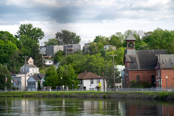 Church and houses by river at Falls View Park, Albany, New York, USA