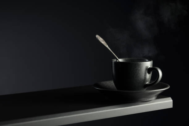 Minimalist Black Coffee Cup with Spoon on Soft Teal Background Reflecting Modern Elegance