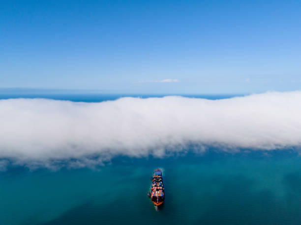 istock Aerial front view of a large container cargo ship travels over calm, blue ocean. 2155737876