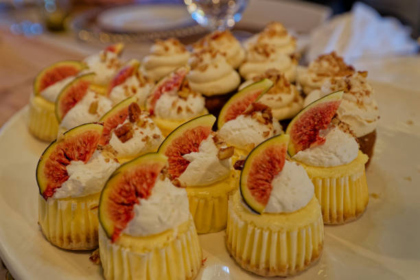 istock A plate full of small cupcakes with cream and fig pieces toppings. 2155741338