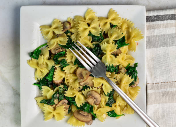 istock farfalle pasta with  spinach and mushrooms 2155743564