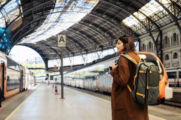 istock Young woman on a journey waiting for a train 2155743673