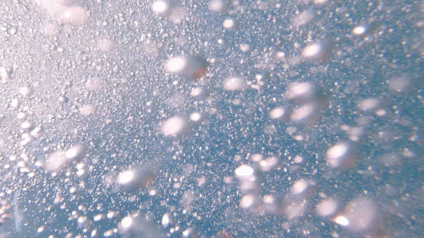 Underwater view of sun shining through bubbles