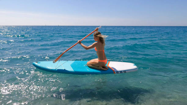 istock Young woman paddle boarding on sea 2155744558