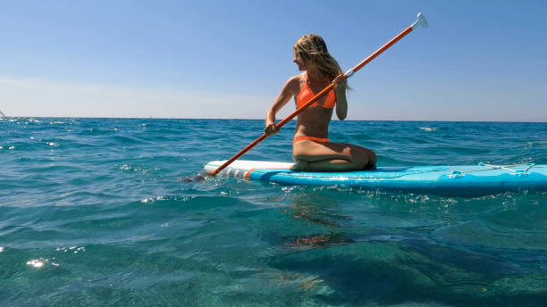 istock Young woman paddle boarding on sea 2155744592