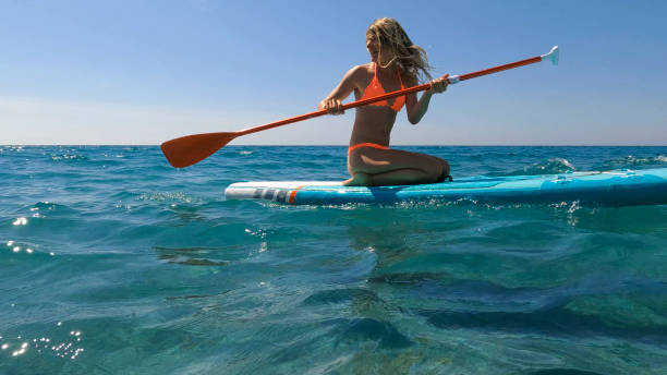 istock Young woman paddle boarding on sea 2155744595