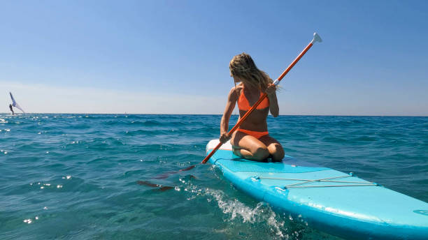 istock Young woman paddle boarding on sea 2155744602