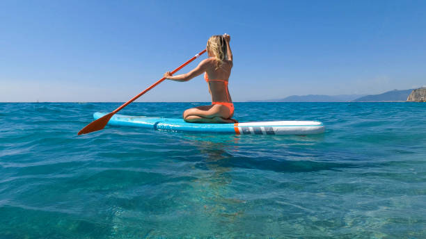 istock Young woman paddle boarding on sea 2155744619