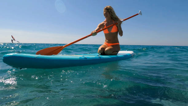 istock Young woman paddle boarding on sea 2155744621