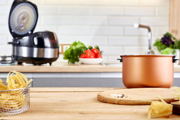 istock Domestic electric multi cooker on wooden table. Housewife using multi-cooker in kitchen. Space for design or text. 2155748873