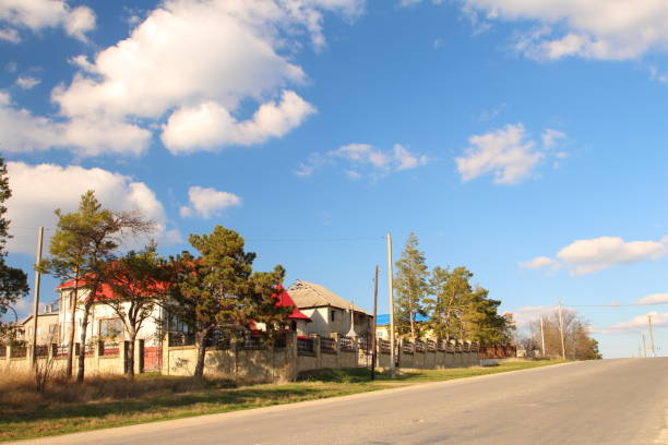 istock A road with trees and houses 2155751034
