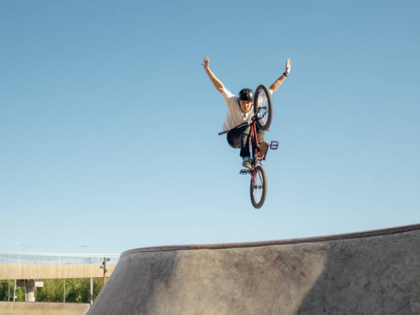 istock BMX bicycle rider doing trick No Hand in quarter 2155755173