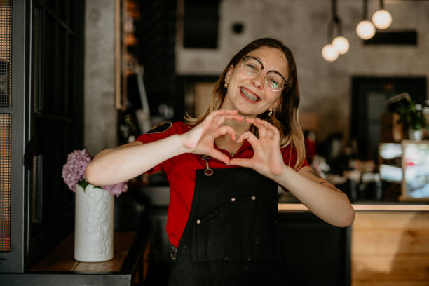 Portrait of a beautiful waitress wearing an apron, smiling at camera