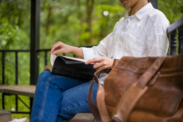 istock young woman reading a book and writing in a camellia 2155758025