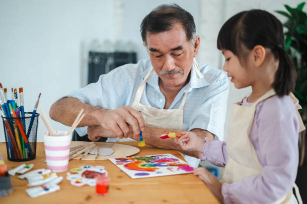 istock Brushing Through Time: Grandfather and Granddaughter's Artistic Bond 2155761050