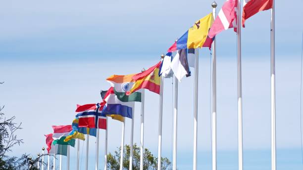 istock Row of Flagposts with National Flags Waving in the Wind 2155763194