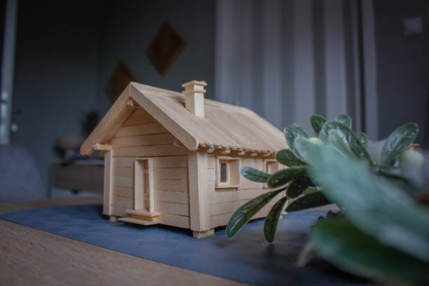 Small wooden model of a country house with natural decorations on table