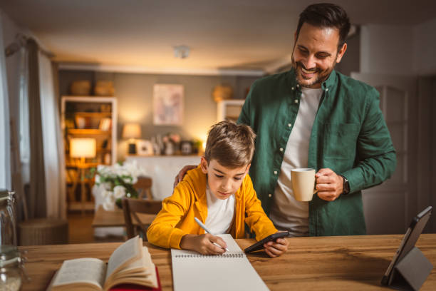 istock Father with cup help son who copy notes from mobile phone at home 2155771560