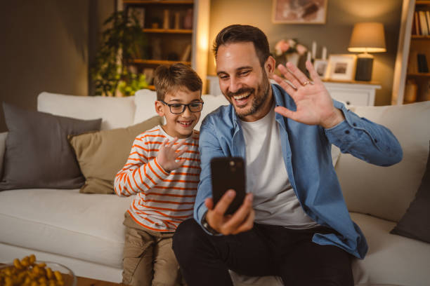 istock Father and son use mobile phone for video call at home 2155771983
