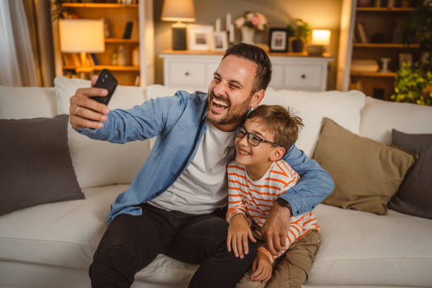 istock Father and son use mobile phone for video call at home 2155772418